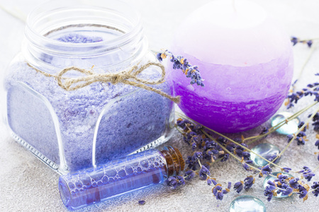 Spa and wellness setting with lavender flowers, sea salt, oil in a bottle, aroma candle on wooden white background closeupの写真素材