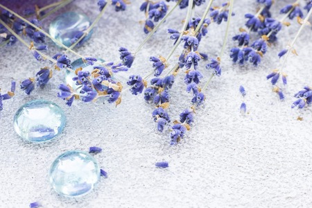 Spa and wellness setting with lavender flowers, sea salt, oil in a bottle, aroma candle on wooden white background closeupの写真素材