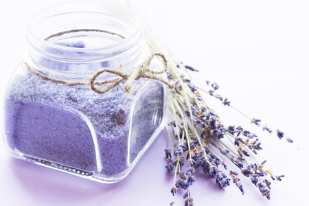 Spa and wellness setting with lavender flowers, sea salt, oil in a bottle, aroma candle on wooden white background closeupの写真素材