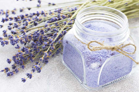 Spa and wellness setting with lavender flowers, sea salt, oil in a bottle, aroma candle on wooden white background closeupの写真素材