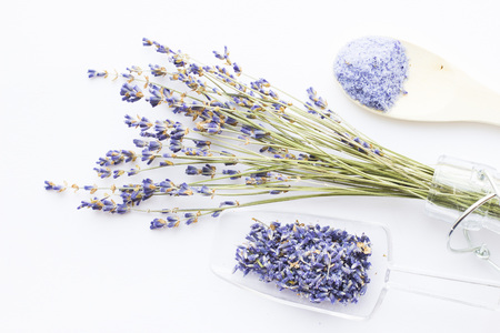 Spa and wellness setting with lavender flowers, sea salt, oil in a bottle, aroma candle on wooden white background closeupの写真素材