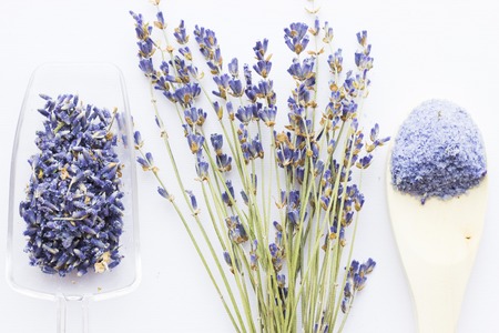 Spa and wellness setting with lavender flowers, sea salt, oil in a bottle, aroma candle on wooden white background closeupの写真素材