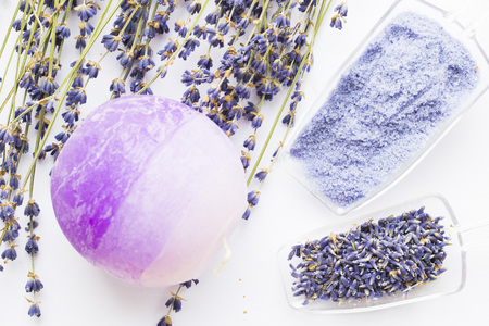 Spa and wellness setting with lavender flowers, sea salt, oil in a bottle, aroma candle on wooden white background closeupの写真素材