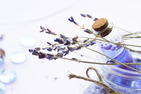 Spa and wellness setting with lavender flowers, sea salt, oil in a bottle, aroma candle on wooden white background closeupの写真素材