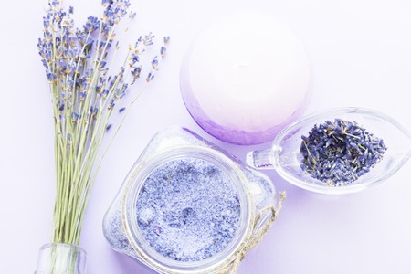 Spa and wellness setting with lavender flowers, sea salt, oil in a bottle, aroma candle on wooden white background closeupの写真素材
