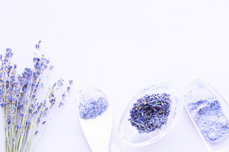 Spa and wellness setting with lavender flowers, sea salt, oil in a bottle, aroma candle on wooden white background closeupの写真素材
