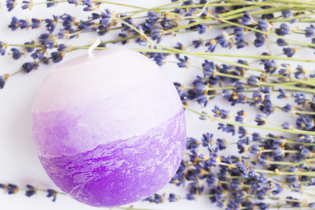 Spa and wellness setting with lavender flowers, sea salt, oil in a bottle, aroma candle on wooden white background closeupの写真素材