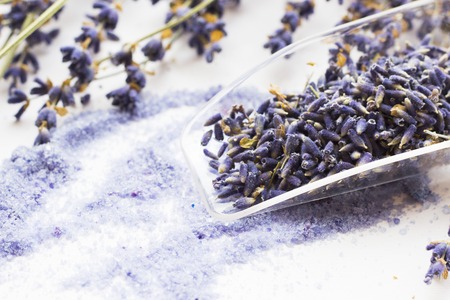 Spa and wellness setting with lavender flowers, sea salt, oil in a bottle, aroma candle on wooden white background closeupの写真素材