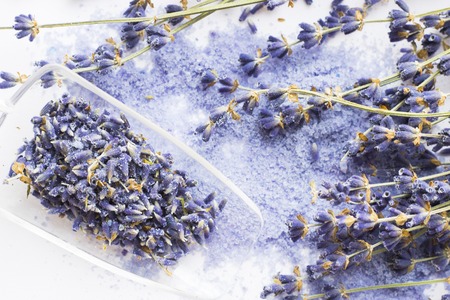 Spa and wellness setting with lavender flowers, sea salt, oil in a bottle, aroma candle on wooden white background closeupの写真素材