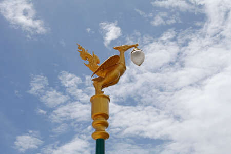 Light pole sculpture, Swan creature holding lamp の写真素材