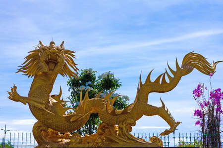 Golden Dragon in Chinese temple surrounded by beautiful tree canopy.; の写真素材