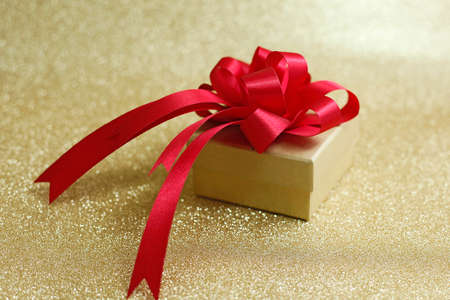 Christmas gift on Decorative background in gold with sparkling starsの写真素材