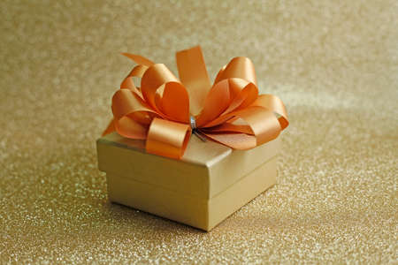 Christmas gift on Decorative background in gold with sparkling starsの写真素材