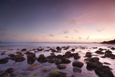 Sea waves lash line impact rock onthe beach