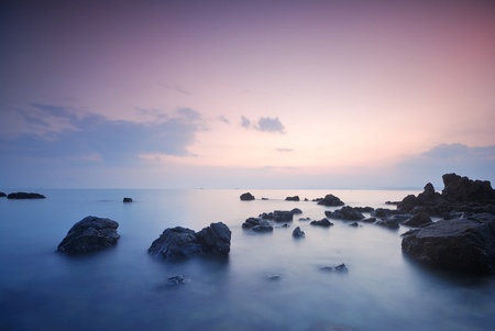 Sea waves lash line impact rock onthe beachの写真素材