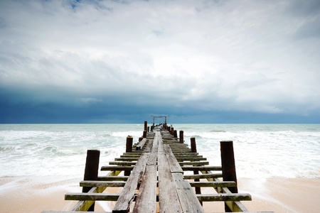 Filed wooden bridge into the sea after sunset on the beachの写真素材