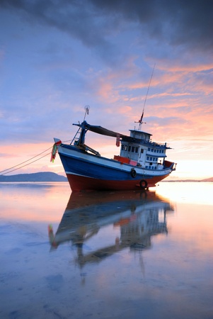 Thai fishing boat used as a vehicle for finding fish in the sea.at sunsetの写真素材