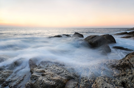 Sea waves lash line impact rock on the beachの写真素材