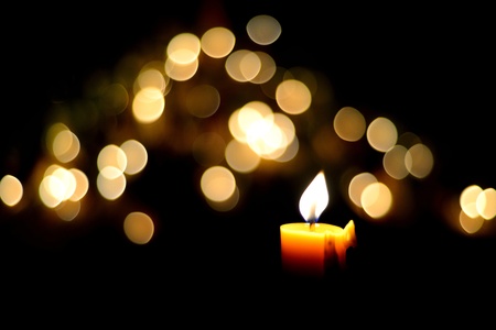 One candle flame at night with bokehの写真素材