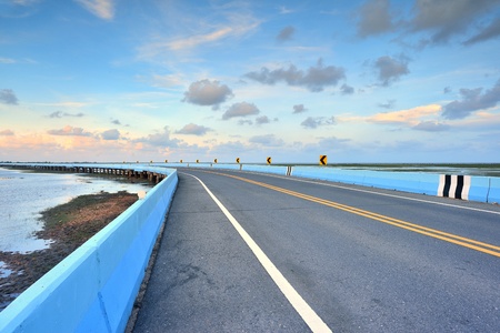 asphalt road to horizon in cloudy sky の写真素材