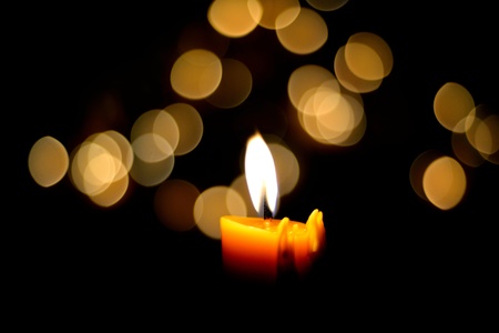 One candle flame at night with bokehの写真素材