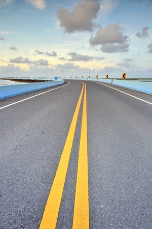 asphalt road to horizon in cloudy sky の写真素材
