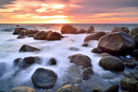 Sea waves lash line impact rock on the beachの写真素材