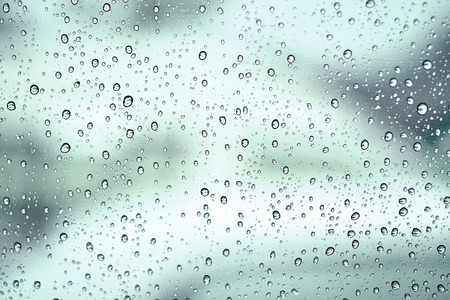 drops of rain on window with bokeh lights abstract の写真素材