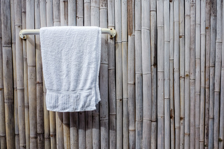 white towel hanging on bamboo wall backgroundの写真素材