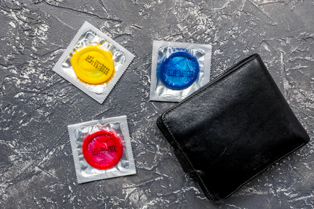 male contraception with condom and wallet on dark table background top viewの写真素材