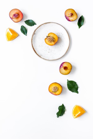 tropical fruits design with sliced orange and peach on plate on white table background top view mock upの写真素材