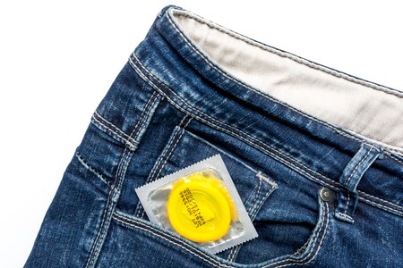 Condoms in package and jeans white background top viewの写真素材