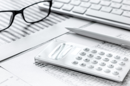Business report preparing with calculator and glasses on office backgroundの写真素材
