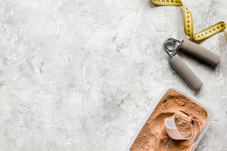 Whey protein powder for fitness nutrition to start training and measure tape on stone background top view mockupの写真素材