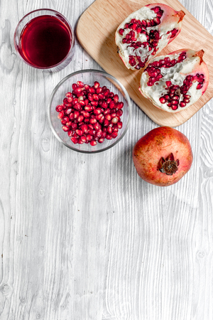 Red sliced pomegranate and juice in glass on wooden background top view mock upの写真素材