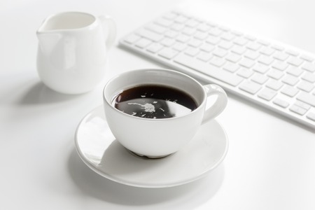 coffee, milk and croissant for breakfast of businessman on white office desk backgroundの写真素材