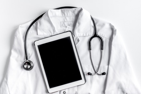 Medical equipment with stethoscope and tablet in doctor's office in hospital on white desk background top view mock-upの写真素材