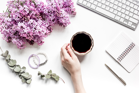 Work desk with lilac flowers in home office on white background top view space for textの写真素材