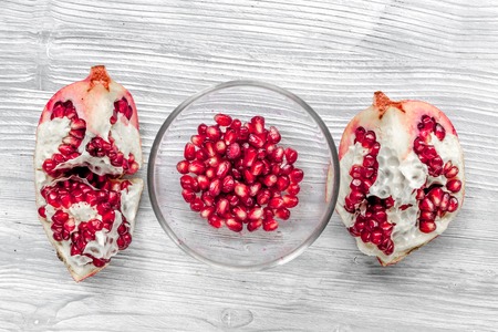 summer dessert with red cut pomegranate on light wooden desk background top viewの写真素材