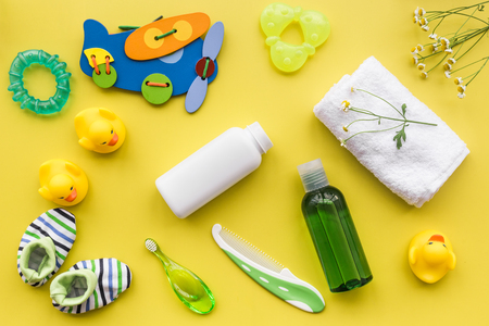 baby accessories for bath with body cosmetic and toy ducks on yellow background top view patternの写真素材