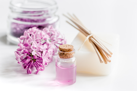 lilac cosmetics with flowers and spa set on white table backgroundの写真素材