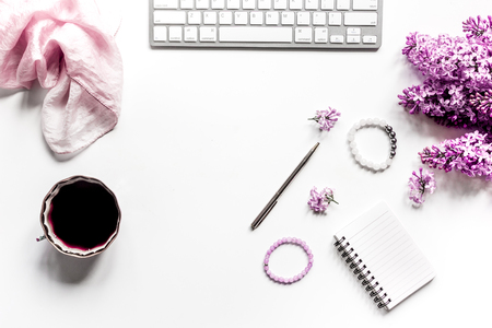 Woman office desk with keyboard, coffee and lilac blossom design white background top view mockupの写真素材