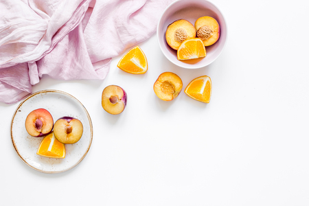 tropical peach and orange fruits for fresh summer juice with towel on white table background top view space for textの写真素材