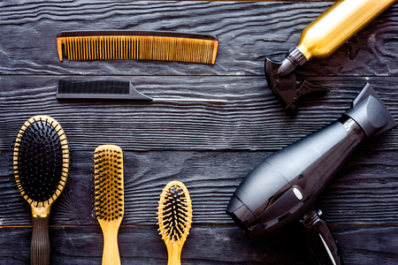 Comb brushes, hairdryer and hairspray on grey wooden background top view.の写真素材