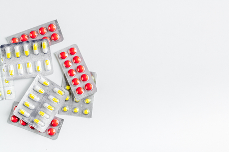 doctors work desk in hospital with pills white background top view mockupの写真素材