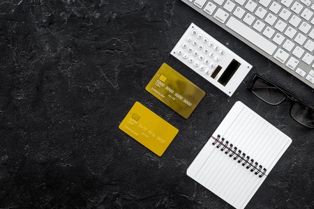 accountant work desk with credit card and notebook for online payment dark background top view space for textの写真素材