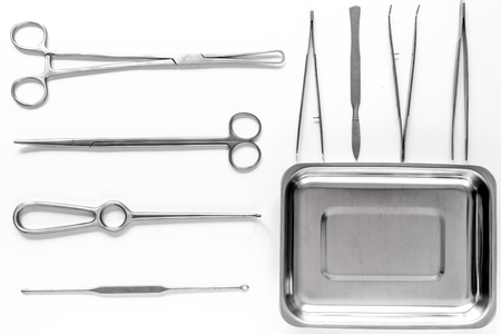surgical instruments and tools including scalpels, forceps and tweezers on white table top view.の写真素材