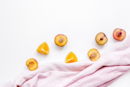 Orange and peach summer sweet dessert on fabric white desk background top view mock-upの写真素材