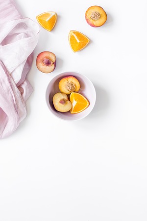 tropical peach and orange fruits for fresh summer juice with towel on white table background top view space for textの写真素材