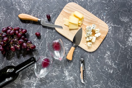 Set for drinking wine with cheese and red grape on grey stone background top viewの写真素材